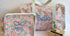 Floral-patterned bags with 'Bella' and 'FB' monograms on a white background